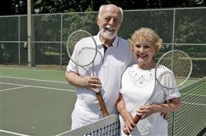 Smiling Senior Couple at Tennis Net